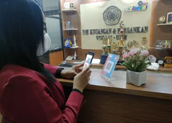 Mahasiswa tengah melakukan scan QR Code dalam transaksi pembayaran lewat aplikasi Link Aja.