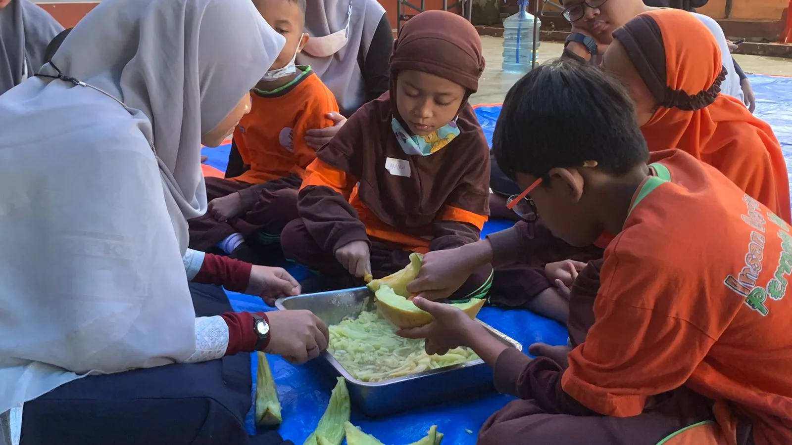 Keseruan salah satu kelompok saat menyerut buah melon.