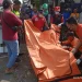 Petugas mengevakuasi jenazah korban.