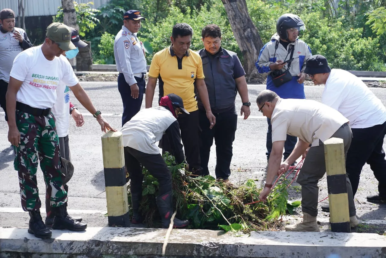 Pj Wali Kota Batu, Aries Agung Paewai, saat ikut terjun langsung dalam kegiatan Rijik-Rijik Kali di Kota Batu.