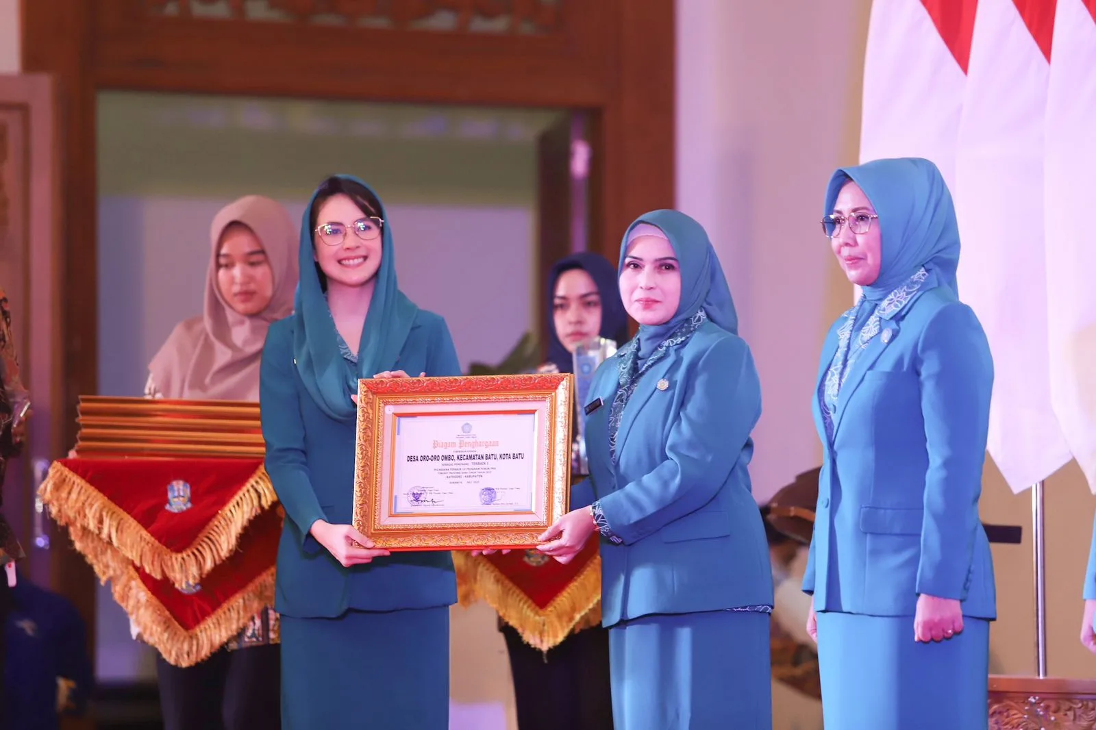 Ketua TP PKK Provinsi Jawa Timur, Arumi Bachsin menyerahkan piagam penghargaan Juara I program Pokok PKK kepada Pj. Ketua TP PKK Kota Batu, Dwi Mardiana.