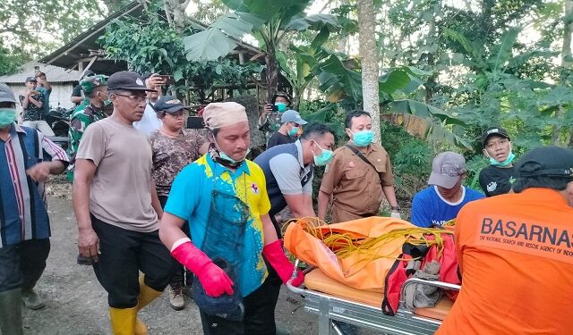 Petugas mengevakuasi korban yang tewas terseret luapan air sungai di Bantur.