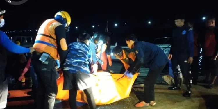 Petugas mengevakuasi tubuh korban yang tenggelam di Bendungan Sutami.
