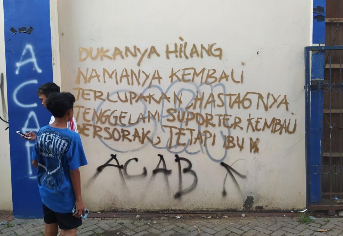 orehan grafiti kata-kata dari suporter yang kecewa atas penegakan keadilan Tragedi Kanjuruhan di tembok Stadion Kanjuruhan. 