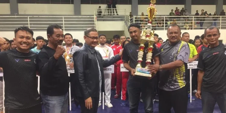Pj Wali Kota Batu, Aries Agung Paewai, menyerahkan Piala Wali Kota Kejurprov Gulat Jatim kepada atlet Kota Batu.