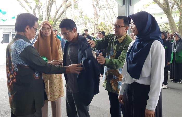 Rektor UIN Malang (kiri) menyematkan jas almamater secara simbolis kepada perwakilan mahasiswa.