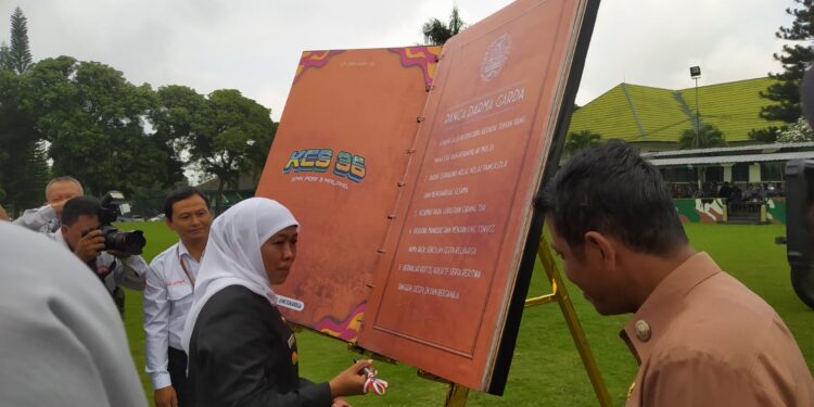 Khofifah menandatangi penyerahan donasi buku 'Panca Darma Garda' secara simbolis dari SMK PGRI 3 Malang kepada Perpustakaan Anak Jabung.