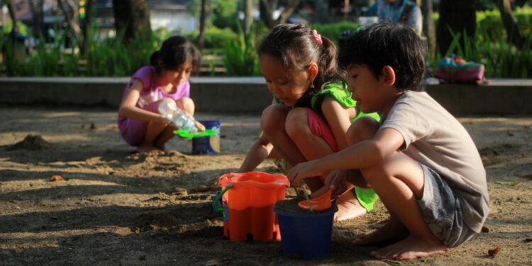 Tiga orang anak bermain di Taman Merbabu, Kota Malang, milik Pemerintah Kota Malang, Senin (10/7/2023).