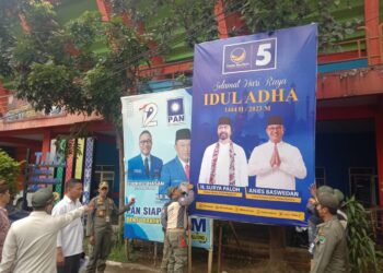 Petugas Satpol PP Kota Malang mencopoti reklame parpol di jalanan Kota Malang.