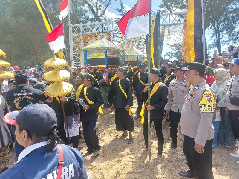 Warga mengarak sesaji sebelum dilarung ke laut.