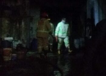 Petugas melakukan penanggulangan kebakaran di rumah produksi keripik di Dau.