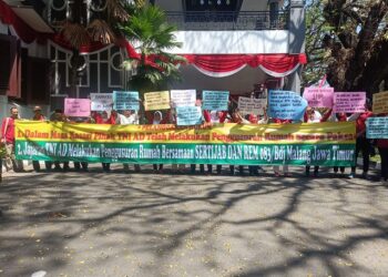 Warga Kelurahan Kestrian, Kota Malang membentangkan poster aspirasi di DPRD Kota Malang.