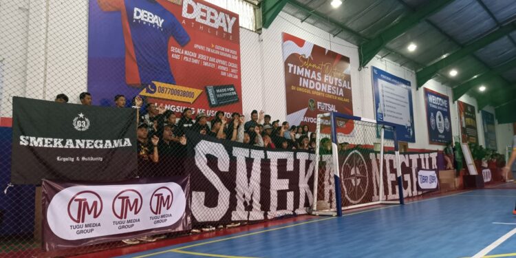 Kelompok suporter SMKN 3 Malang saat memberikan dukungan bagi tim kesayangannya di lapangan Futsal Unggul Sport Center, Sabtu (26/08/23).