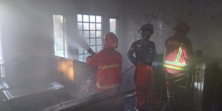 Petugas melakukan pembasahan dalam proses pemadaman kebakaran di SD Plus Al Kautsar Kota Malang.