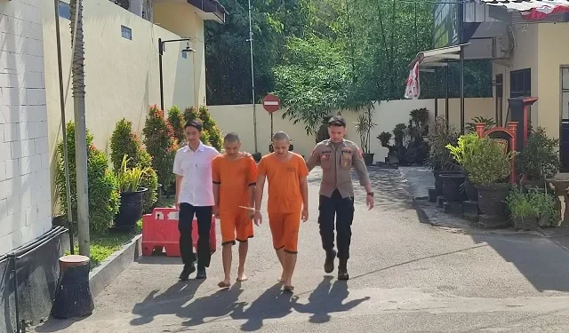 Kedua tersangka saat digelandang di Polres Malang.