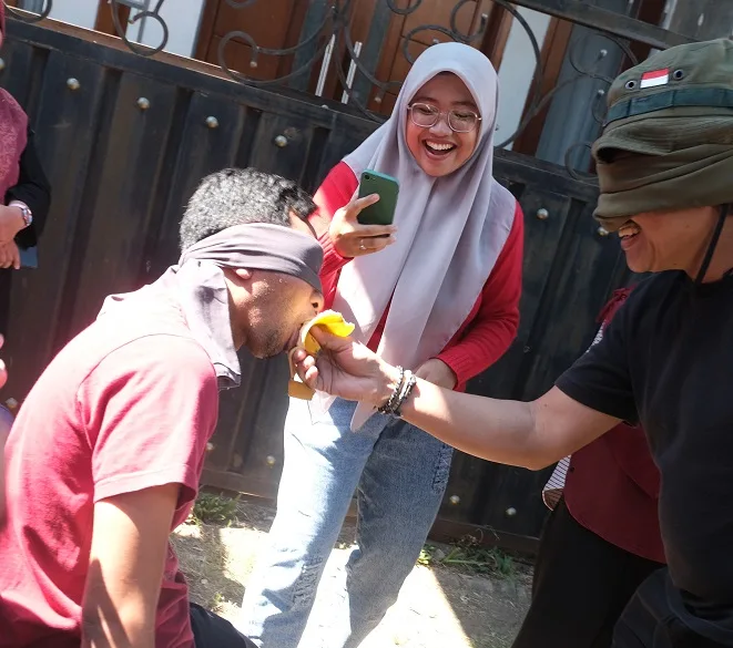 Lomba makan pisang dengan mata ditutup