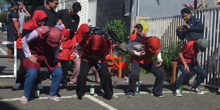 Lomba memasukkan paku dalam botol oleh warga Perum Permata Kencana Saxofon, Kota Malang, Minggu (13/8/2023).