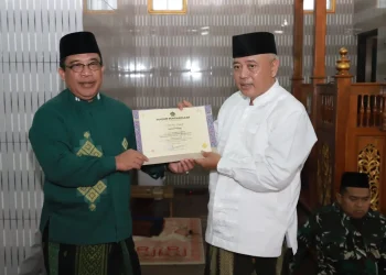 Kepala Kantor Kementerian Agama Kabupaten Malang, Sahid (kiri) menyerahkan penghargaan kepada Bupati Malang, Sanusi (kanan).