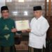 Kepala Kantor Kementerian Agama Kabupaten Malang, Sahid (kiri) menyerahkan penghargaan kepada Bupati Malang, Sanusi (kanan).
