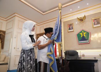 Sutiaji didampingi Widayati Sutiaji mencium bendera Kota Malang sebagai simbol perpisahannya di akhir jabatannya.