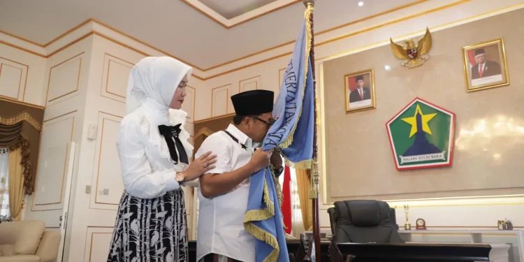 Sutiaji didampingi Widayati Sutiaji mencium bendera Kota Malang sebagai simbol perpisahannya di akhir jabatannya.