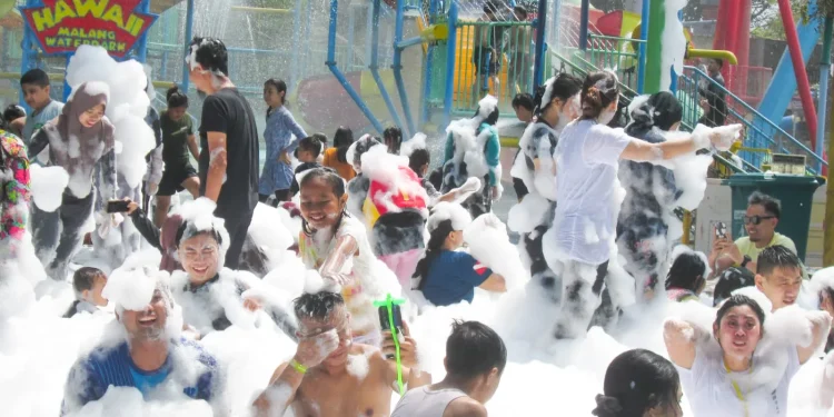 Pengunjung asyik bermain busa setelah ombak tsunami di Hawai Waterpark, Minggu (17/9/2023.