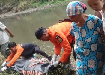 Petugas mengevakuasi jenazah korban.