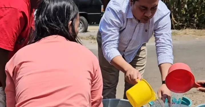 H Puguh Wiji Pamungkas, saat membagikan air.