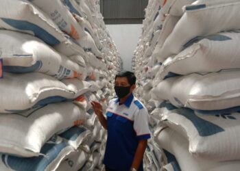 Petugas memantau penataan beras di Gudang Beras Bulog Malang.