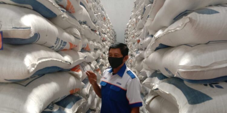 Petugas memantau penataan beras di Gudang Beras Bulog Malang.