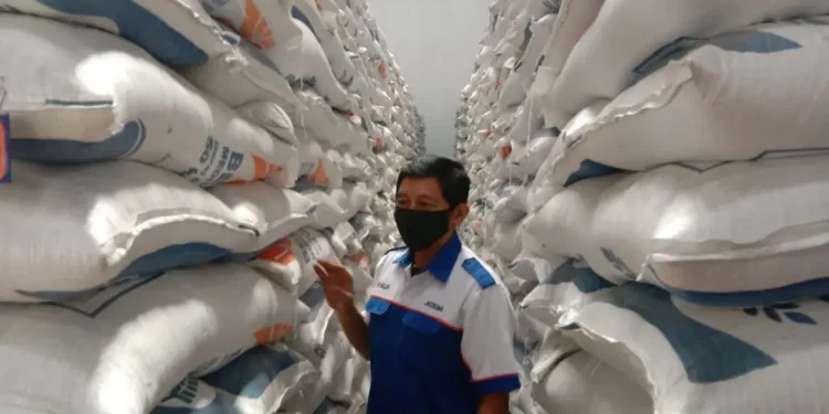 Petugas memantau penataan beras di Gudang Beras Bulog Malang.