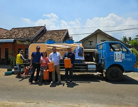 H Puguh Wiji Pamungkas saat membagikan air.