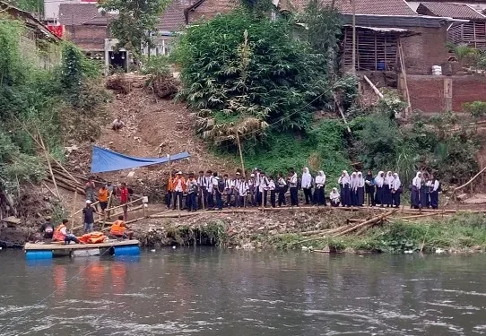 Siswa di Kota Malang menyeberangi Sungai Brantas dengan menggunakan perahu rakit saat jembatan diperbaiki.