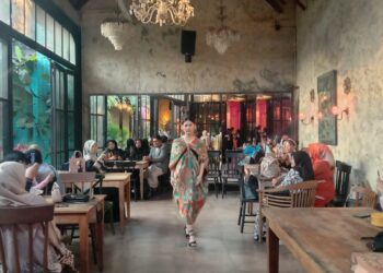 Model fashion show mengenakan kain wastra bermotif batik tampil melenggak lenggok di antara meja kafe pengunjung Souk Bistro Kota Malang.