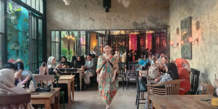 Model fashion show mengenakan kain wastra bermotif batik tampil melenggak lenggok di antara meja kafe pengunjung Souk Bistro Kota Malang.