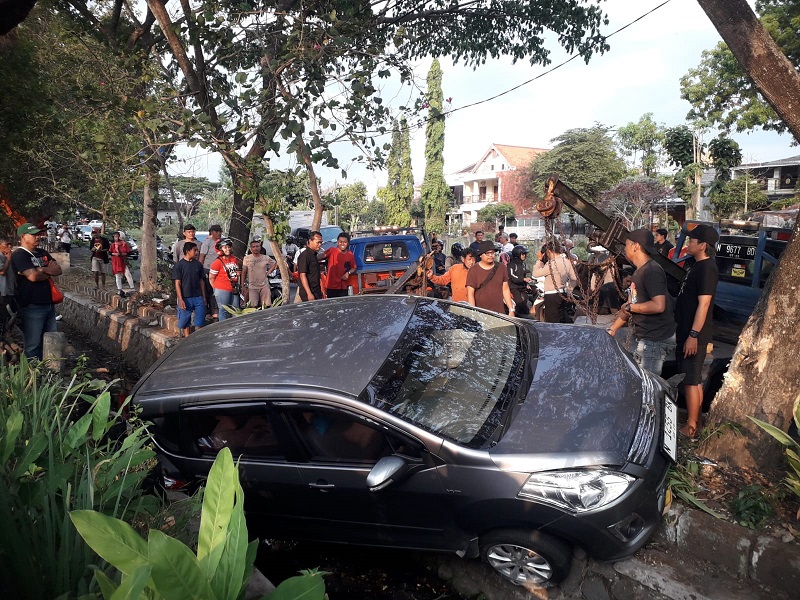 Mobil yang mengalami kecelakaan dan masuk sungai di Jalan Raya Sawojajar, Kota Malang. 