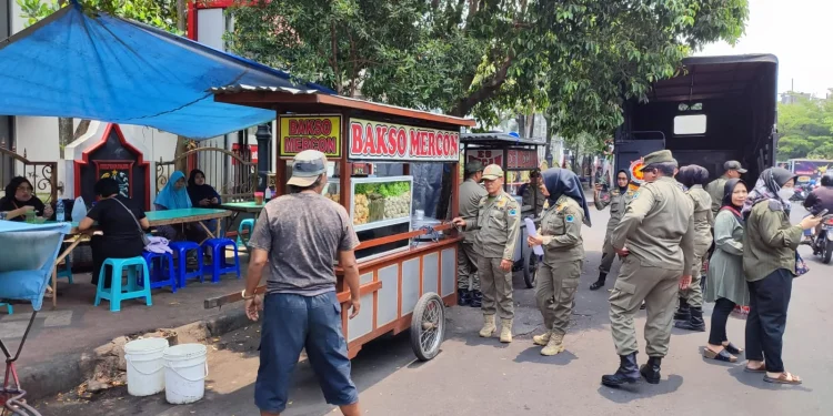 Petugas menindak pedagang PKL di Kota Malang yang berjualan di bahu jalan dan trotoar.