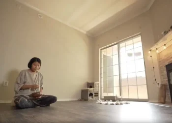 Seorang perempuan minimalis yang tinggal di rumah tanpa furniture.