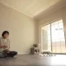 Seorang perempuan minimalis yang tinggal di rumah tanpa furniture.