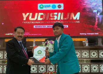 Dekan FH Unisma menyerahkan SKL kepada salah satu lulusan.