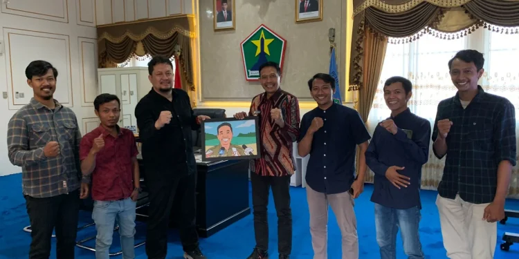 Pj Wali Kota Malang, Wahyu Hidayat menerima cindera mata dari Tugu Media Group.