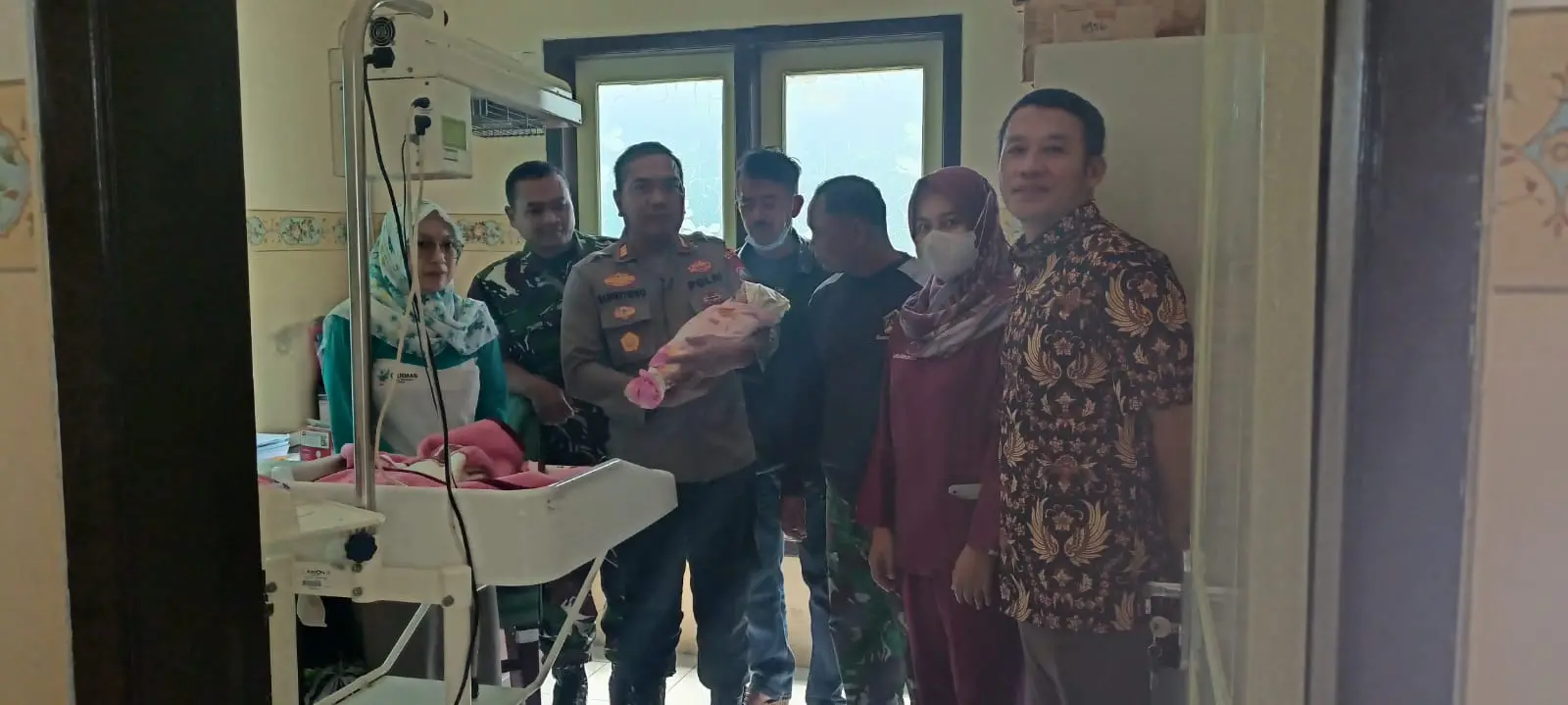 Kapolsek Pagak, AKP Supriyono menggendong bayi perempuan yang ditemukan dalam kresek hitam. 