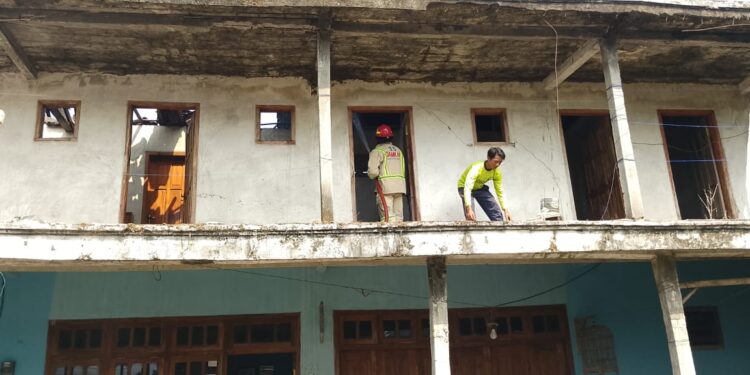 Petugas melakukan penangulangan kebakaran di rumah Siti Rosidah.
