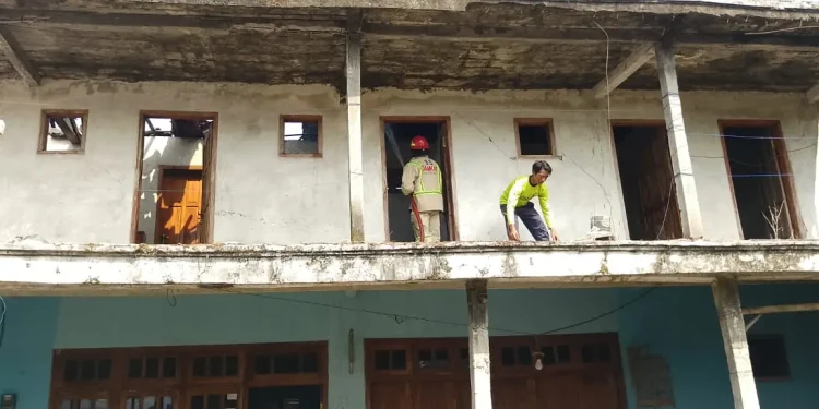 Petugas melakukan penangulangan kebakaran di rumah Siti Rosidah.