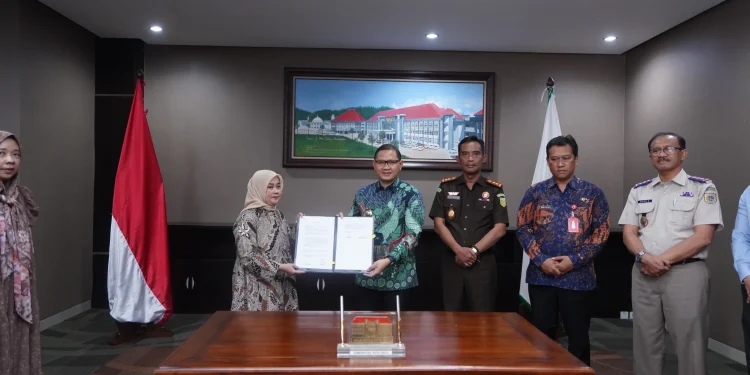 Pj Wali Kota Batu Aries Agung Paewai saat menerima srcara simbolis penyerahan PSU dari 3 pengembang perumahan di Kota Batu. Foto: Prokopim KWB