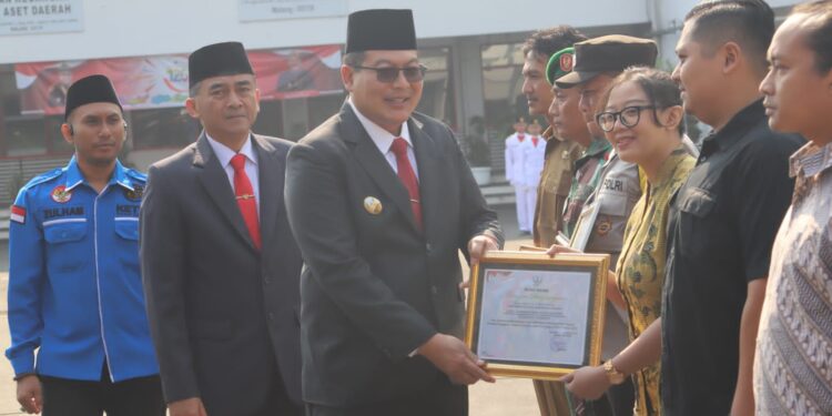 Wakil Bupati Malang, Didik Gatot Subroto menyerahkan penghargaan pada pemuda berprestasi.