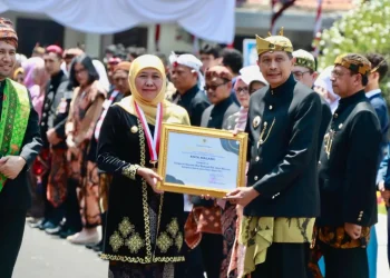 Gubernur Khofifah menyerahkan penghargaan kepada Pj Wali Kota Malang Wahyu Hidayat.