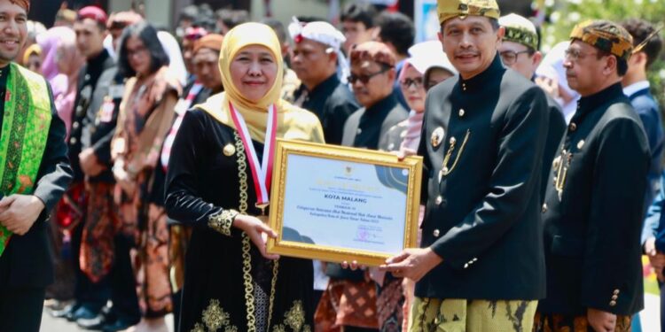 Gubernur Khofifah menyerahkan penghargaan kepada Pj Wali Kota Malang Wahyu Hidayat.