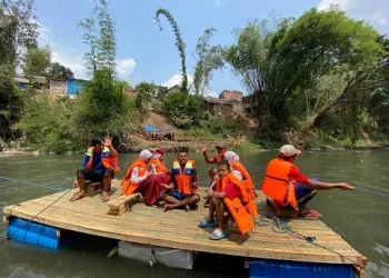 Siswa SD yang menyeberangi Sungai Brantas menggunakan perahu rakit.
