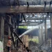 Petugas melakukan pemadaman di tempat pembuatan batu bakar yang terbakar.